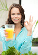 woman holding glass of juice and showing ok sign