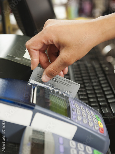 Photo: Mixed race woman swiping credit card in store Mixed race woman swiping credit card in store