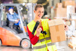 Lageristin von Spedition scannt Paket in Lager