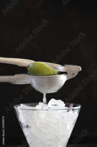 Photo: Lime being squeezed over ice Lime being squeezed over ice