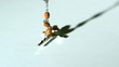 Rosary beads casting a shadow and then falling