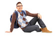 Smiling male student sitting on the floor