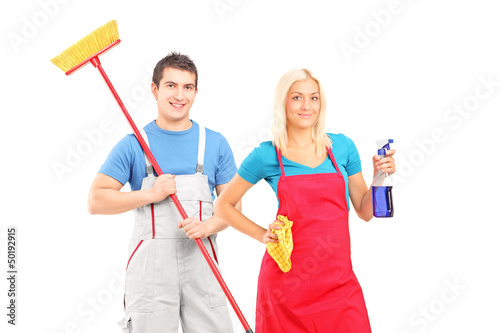 Photo: Male and female cleaners with cleaning supplies posing Male and female cleaners with cleaning supplies posing