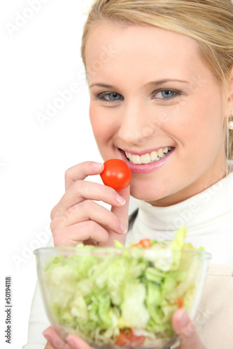 Photo: Blond girl eating salad Blond girl eating salad