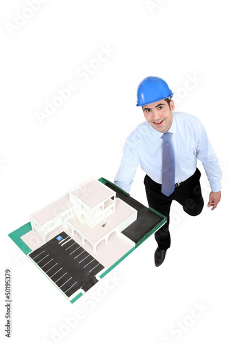 Photo: Businessman holding a model building Businessman holding a model building
