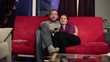 Happy couple watching tv in home