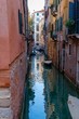 A dark and lonely channel in Venice with boats parked around