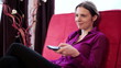 Happy woman on sofa watching tv in home