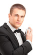 A portrait of a handsome male in black suit using parfume