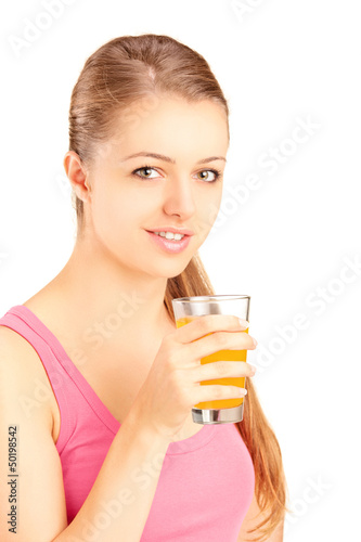 Photo: Female athlete holding a glass of orange juice, refreshing after Female athlete holding a glass of orange juice, refreshing after
