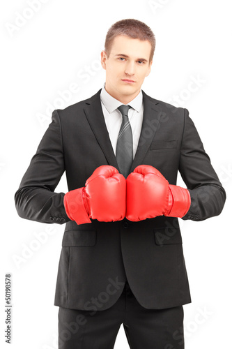Photo: Handsome man in black suit with red boxing gloves posing Handsome man in black suit with red boxing gloves posing