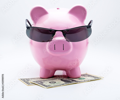 Photo: Tirelire avec lunettes de soleil sur billets US Dollars Tirelire avec lunettes de soleil sur billets US Dollars
