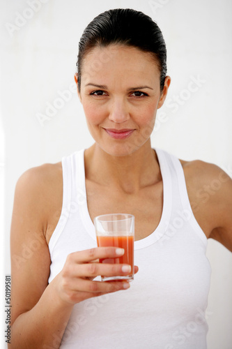 Photo: Brunette holding glass of tomato juice Brunette holding glass of tomato juice