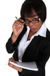 businesswoman looking upwards holding pen and notepad