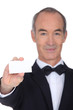 Grey haired waiter displaying business card