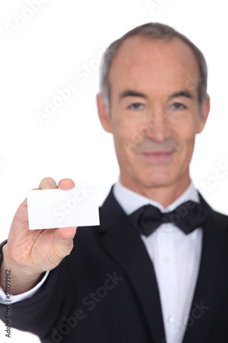 Photo: Grey haired waiter displaying business card Grey haired waiter displaying business card