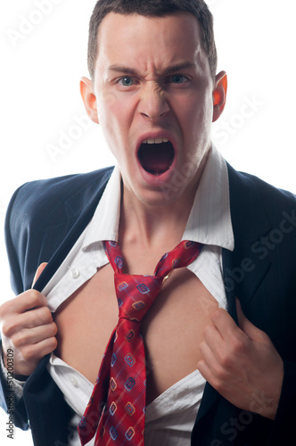 Photo: Young angry businessman tearing his shirt in frustration Young angry businessman tearing his shirt in frustration