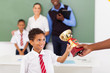 school boy receiving a trophy in classroom