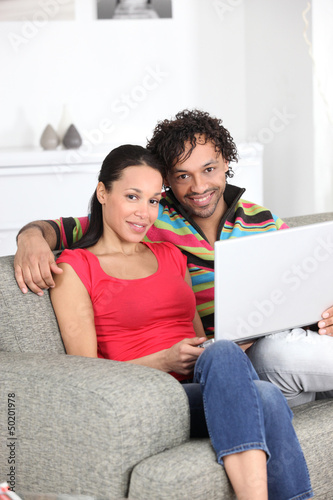 Photo: Metis couple using laptop at home Metis couple using laptop at home
