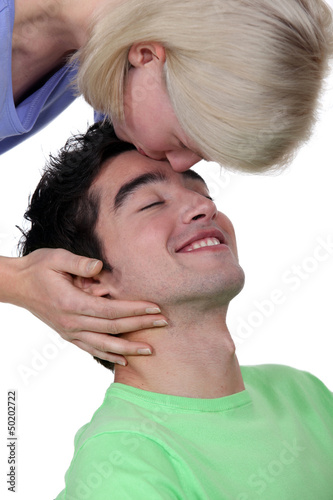 Photo: Woman kissing a man's forehead Woman kissing a man's forehead