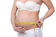 Pregnant woman measuring her abdomen