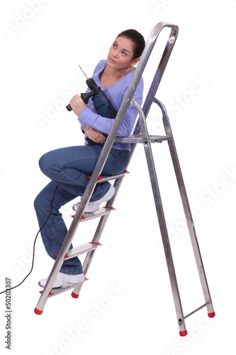 Photo: Handywoman sat on a ladder Handywoman sat on a ladder