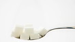 Pile of sugar lumps appearing on teaspoon