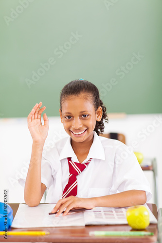 Photo: primary schoolgirl hand up in classroom primary schoolgirl hand up in classroom