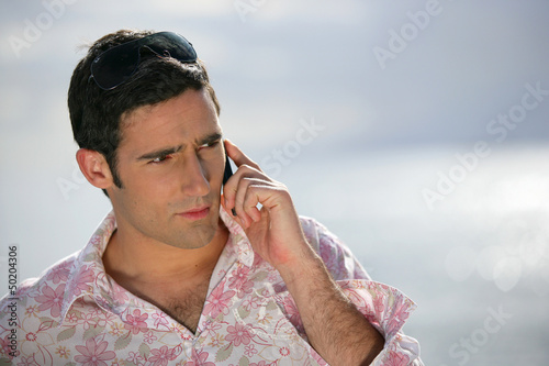 Photo: Worried man talking on the phone Worried man talking on the phone