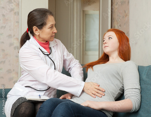 Photo: Doctor touches belly of teenage patient Doctor touches belly of teenage patient