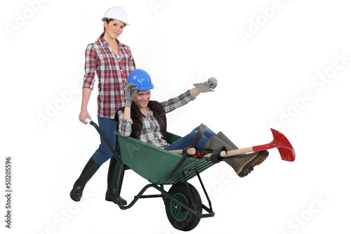Photo: Two women messing around wuth wheelbarrow Two women messing around wuth wheelbarrow