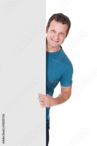 Photo: Man in casual outfit presenting empty banner Man in casual outfit presenting empty banner