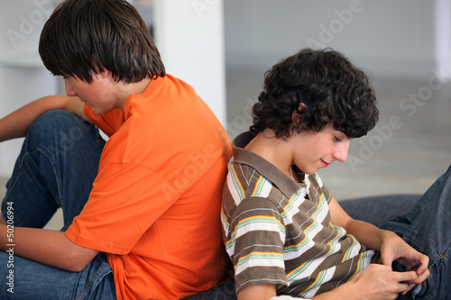 Photo: Teenagers sending phone texts Teenagers sending phone texts