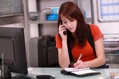 Photo: Woman laborer on phone scheduling an appointment Woman laborer on phone scheduling an appointment