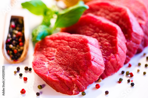 Photo: Raw beef and vegetables on white background Raw beef and vegetables on white background