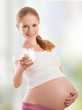 beautiful young pregnant woman and glass of milk