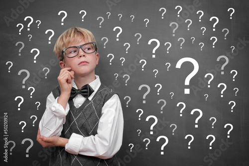 Photo: Boy at the Blackboard with Questionsmarls Boy at the Blackboard with Questionsmarls