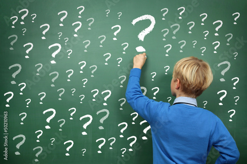 Photo: Boy at the Blackboard with Questionsmarls Boy at the Blackboard with Questionsmarls