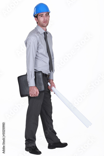 Photo: tired businessman wearing helmet and holding a blueprint tired businessman wearing helmet and holding a blueprint