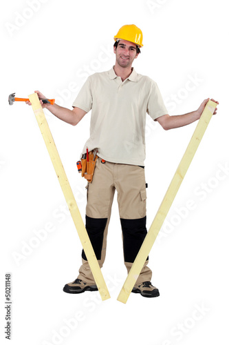 Photo: Worker holding two planks of wood Worker holding two planks of wood