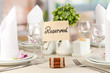 Reserved sign on restaurant table with empty dishes and glasses