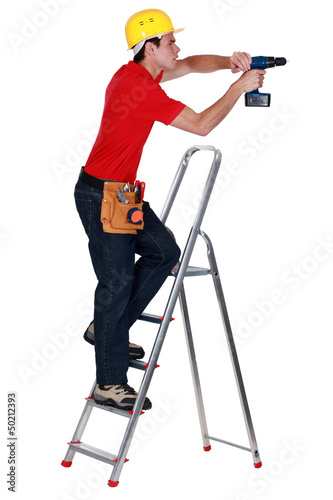Photo: Determined tradesman using a power tool Determined tradesman using a power tool
