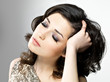 Beautiful woman touches her brown curly hairs