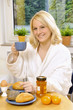 Junge Frau trinkt Kaffee zum Frühstück