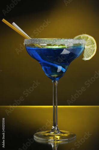 Photo: Blue cocktail in glass on color background Blue cocktail in glass on color background