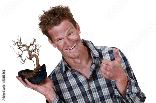 Photo: man covered with dust holding a plant root man covered with dust holding a plant root