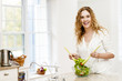 Photo: Smiling woman tossing salad in kitchen Smiling woman tossing salad in kitchen