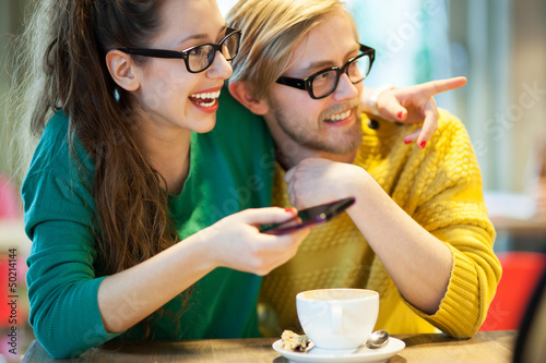 Photo: Young couple in cafe, laughing Young couple in cafe, laughing