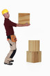 Carpenter lifting heavy block of wood