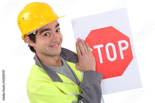Photo: Road worker holding a stop sign. Road worker holding a stop sign.